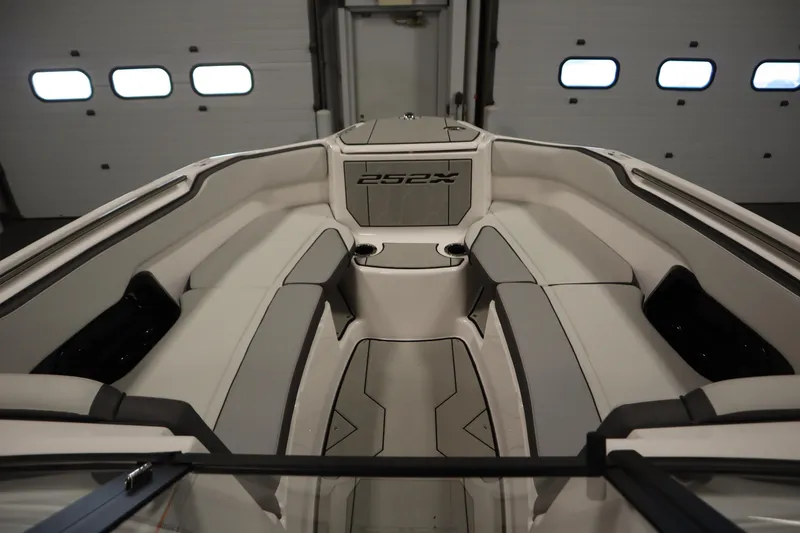 Slide: The Image of 2025 Yamaha Boats 252XE interior, showcasing sleek seating and modern design in a well-lit garage. - 10