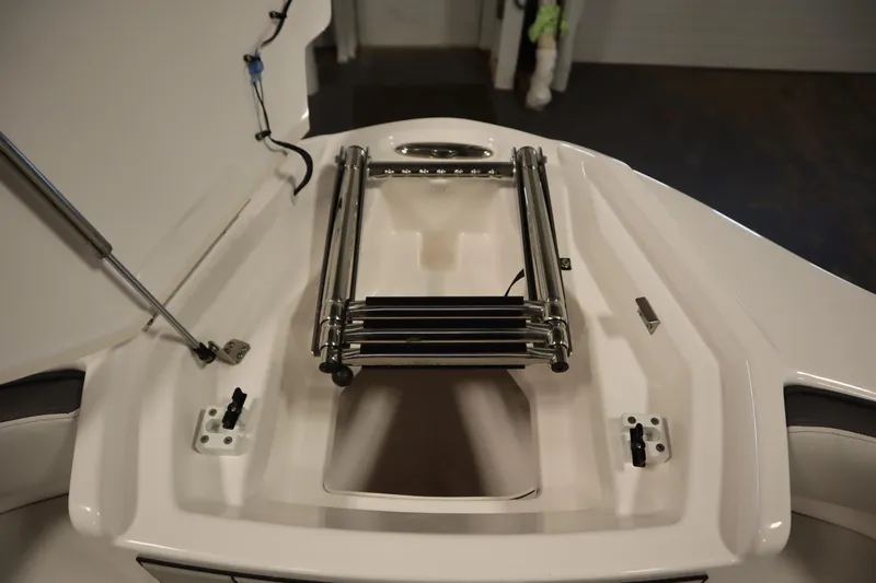 Slide: The Image of 2025 Yamaha Boats 252XE bow storage with foldable ladder and hydraulic support. - 12