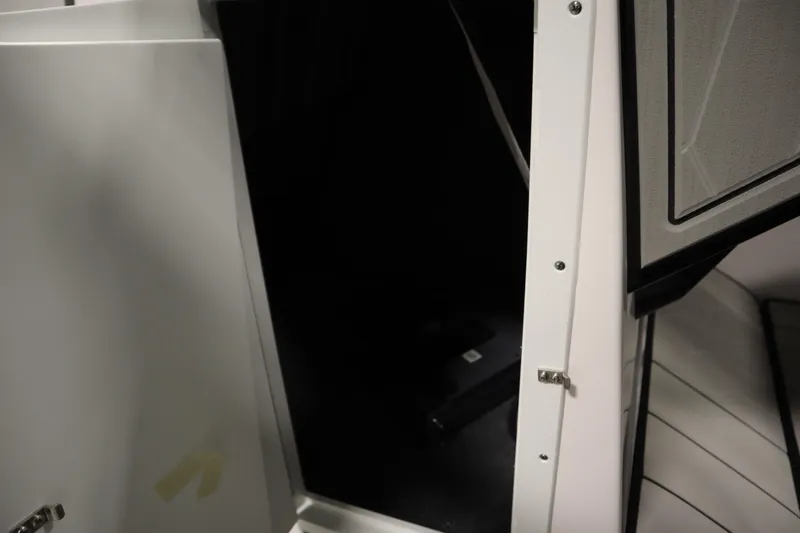 Slide: The Image of 2025 Yamaha Boats 252XE interior storage compartment with open door. - 16