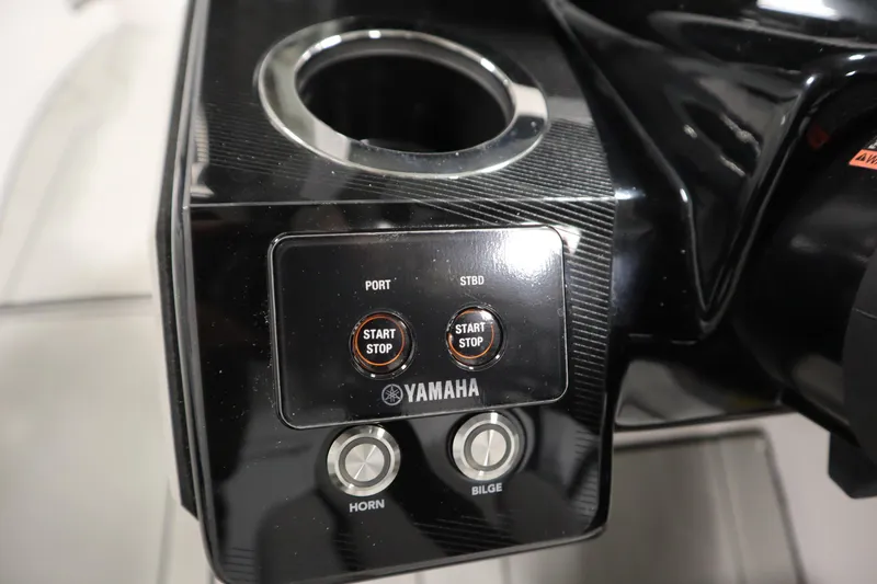 Slide: The Image of Control panel of 2025 Yamaha Boats 252XE with start/stop buttons and cup holder. - 21
