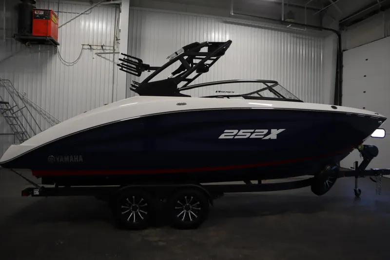 Slide: The Image of 2025 Yamaha Boats 252XE in a showroom, side view, on a trailer. - 3