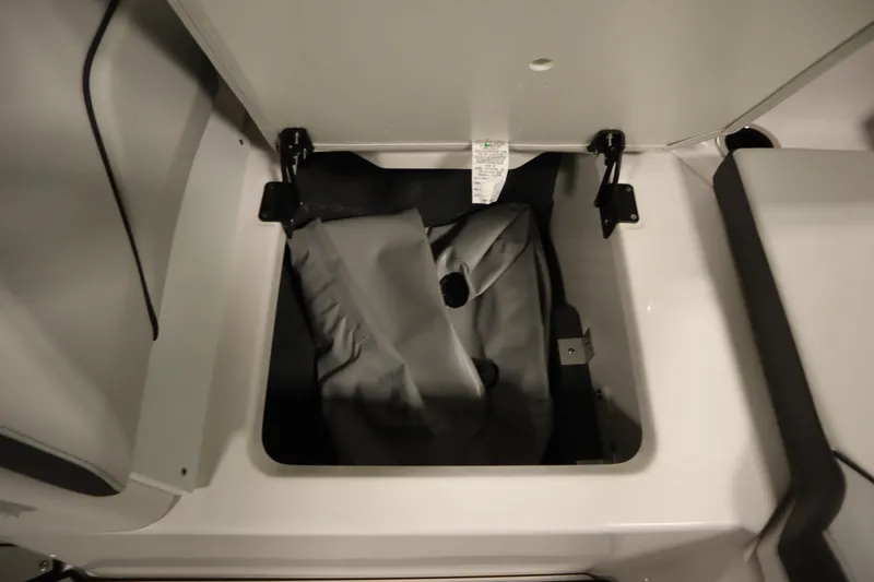 Slide: The Image of Storage compartment of 2025 Yamaha Boats 252XE, featuring a gray cover inside. - 33