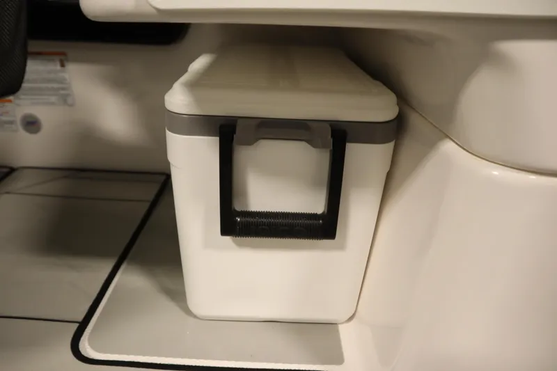 Slide: The Image of 2025 Yamaha Boats 252XE interior storage compartment with a white cooler. - 36