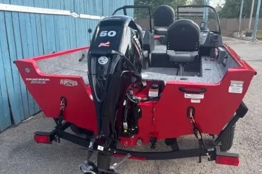 Slide: The Image of Red 2026 Tracker Pro Guide V-16 WT boat with 60 HP motor, parked on trailer. - 4