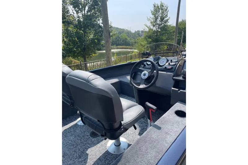 Slide: The Image of 2026 Tracker Super Guide V-16 SC boat interior with steering wheel and seating. - 2