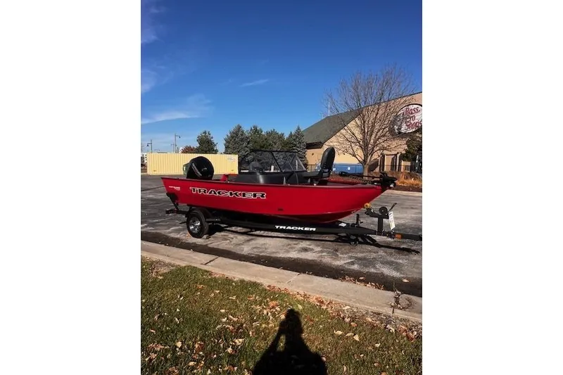 Slide: The Image of 2026 Tracker Pro Guide V-16 WT boat, red, parked outdoors on a trailer. - 53