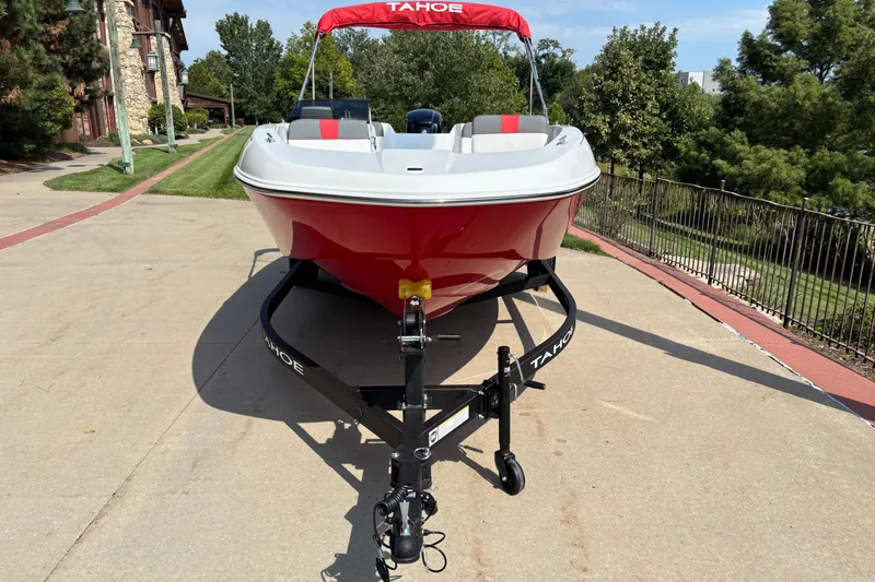 Slide: The Image of 2026 Tahoe T18 boat on trailer, red and white design, parked outdoors. - 2