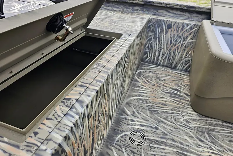 Slide: The Image of 2026 Tracker Grizzly 1754 SC boat interior with camo design and storage compartment. - 13