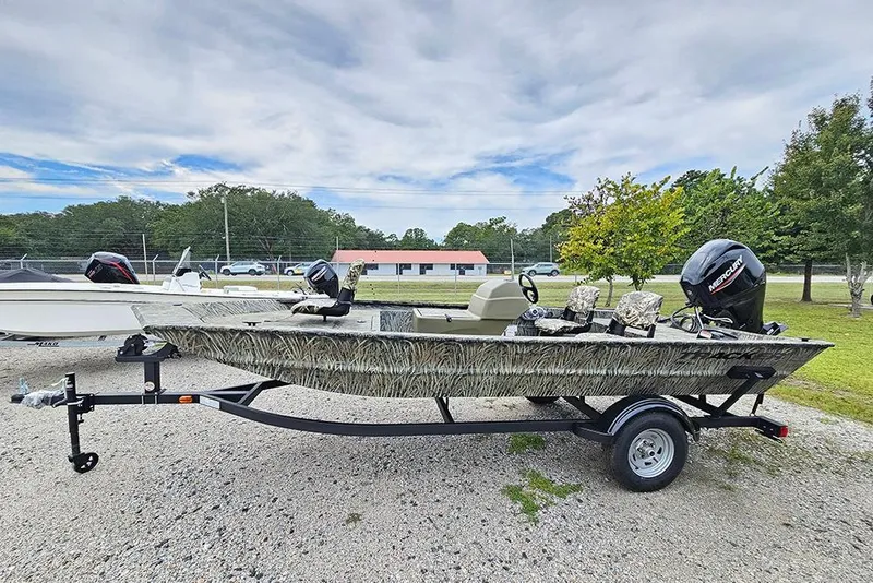 Slide: The Image of 2026 Tracker Grizzly 1754 SC boat on trailer, camo design, parked outdoors. - 6