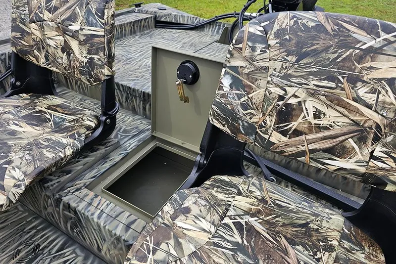 Slide: The Image of 2026 Tracker Grizzly 1754 SC boat interior with camo seats and storage compartment. - 9