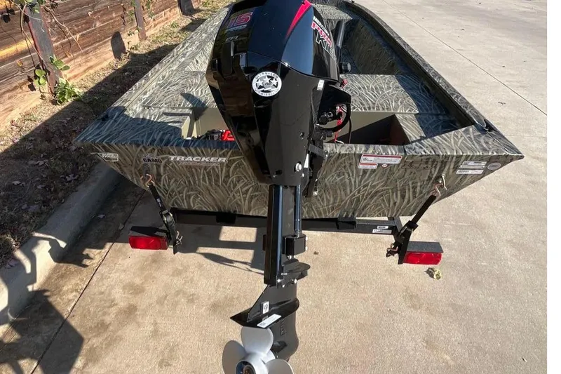 Slide: The Image of 2026 Tracker Grizzly 1648 Utility boat with camouflage design and outboard motor. - 2