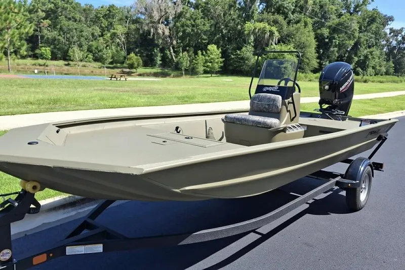 Slide: The Image of 2026 Tracker Grizzly 1860 CC boat on trailer, parked on a paved road. - 2