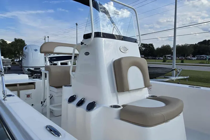 Slide: The Image of 2026 Sundance DX22 boat interior with beige seating and modern console design. - 11