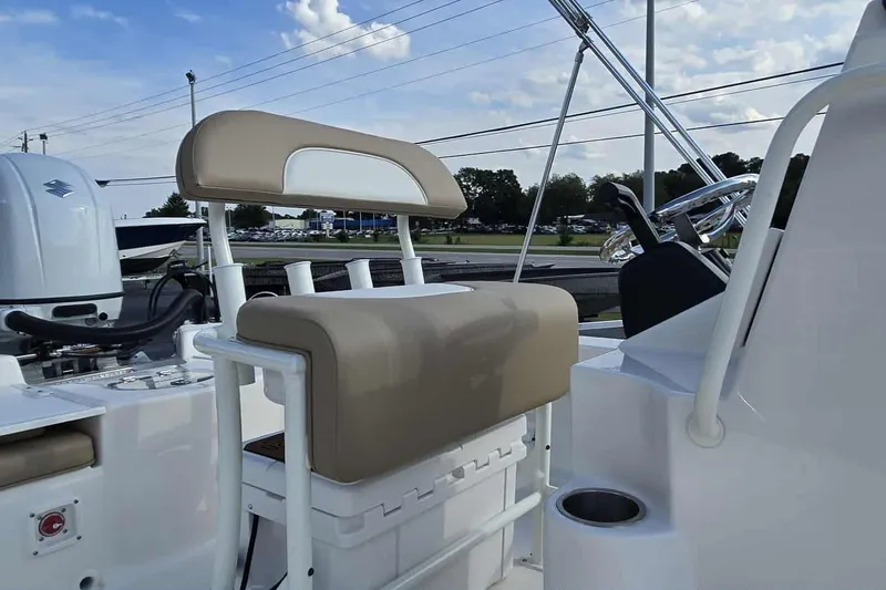 Slide: The Image of 2026 Sundance DX22 boat interior with beige seating and steering wheel. - 12
