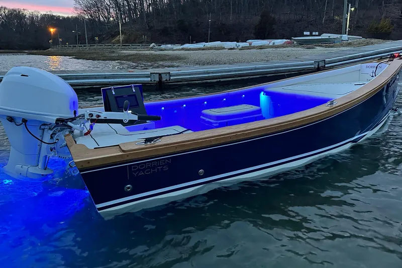 Slide: The Image of 2025 DORRIEN YACHTS 160T 1/1 with blue LED lights docked at sunset. - 27