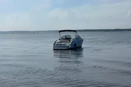 Slide: The Image of 2008 Cobalt 252 boat anchored on calm water under a clear sky. - 11