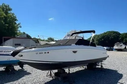 Slide: The Image of 2008 Cobalt 252 boat on stands in a sunny outdoor storage area. - 12