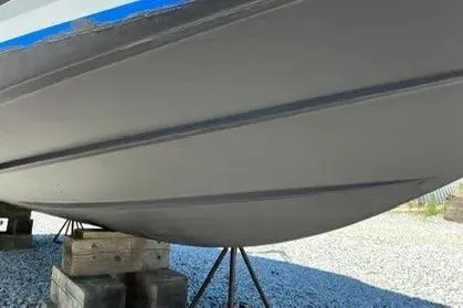 Slide: The Image of 2008 Cobalt 252 boat hull on stands, displayed outdoors on gravel. - 13