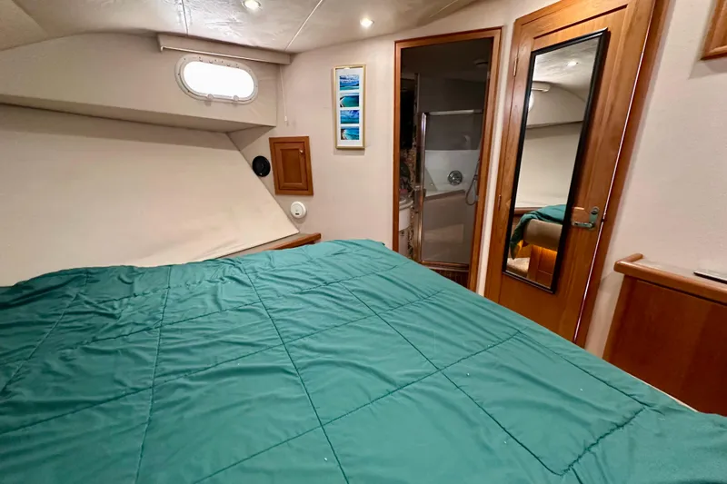 Slide: The Image of Luxurious bedroom interior of 2000 Pacific Mariner 65 Motoryacht with cozy bedding and wooden cabinetry. - 25