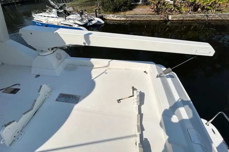 Slide: The Image of 2000 Pacific Mariner 65 Motoryacht deck with davit crane and docked sailboat. - 68