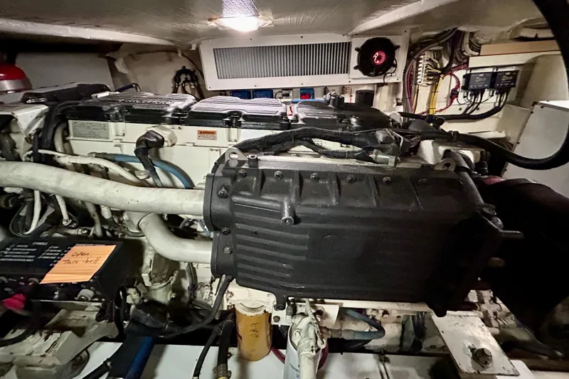Slide: The Image of Engine room of a 2000 Pacific Mariner 65 Motoryacht, showcasing mechanical components and wiring. - 80