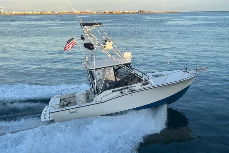 Slide: The Image of 2004 Carolina Classic Express Cabin Cruiser navigating ocean waters with American flag. - 1