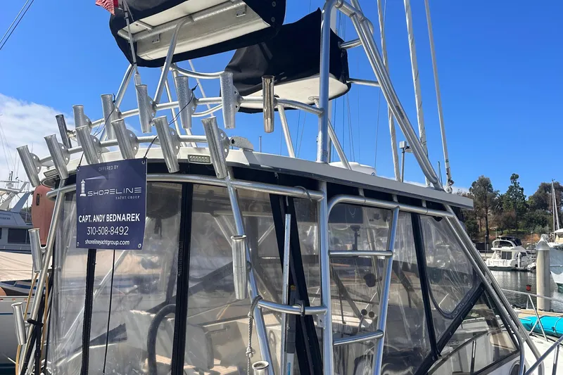 Slide: The Image of 2004 Carolina Classic Express Cabin Cruiser with fishing rod holders at marina. - 16