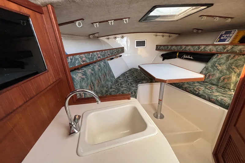 Slide: The Image of 2004 Carolina Classic sport fishing boat interior with sink, table, and patterned seating. - 17