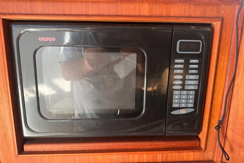 Slide: The Image of Microwave in 2004 Carolina Classic Express Cabin Cruiser, wooden paneling, digital controls. - 24