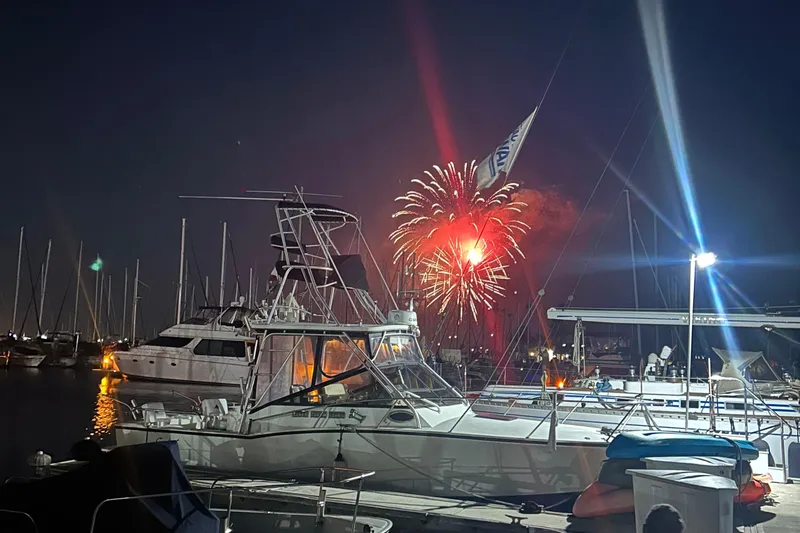Slide: The Image of 2004 Carolina Classic Express Cabin Cruiser with fireworks in marina at night. - 5