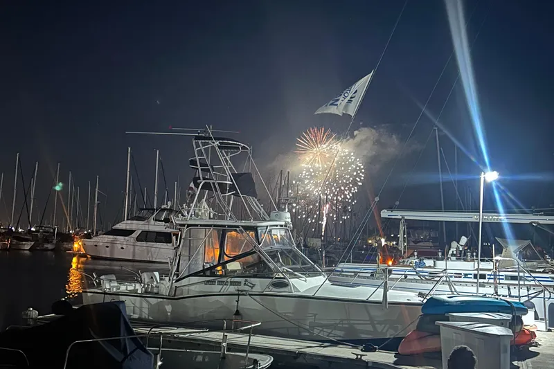 Slide: The Image of 2004 Carolina Classic Express Cabin Cruiser at marina with fireworks in the night sky. - 6
