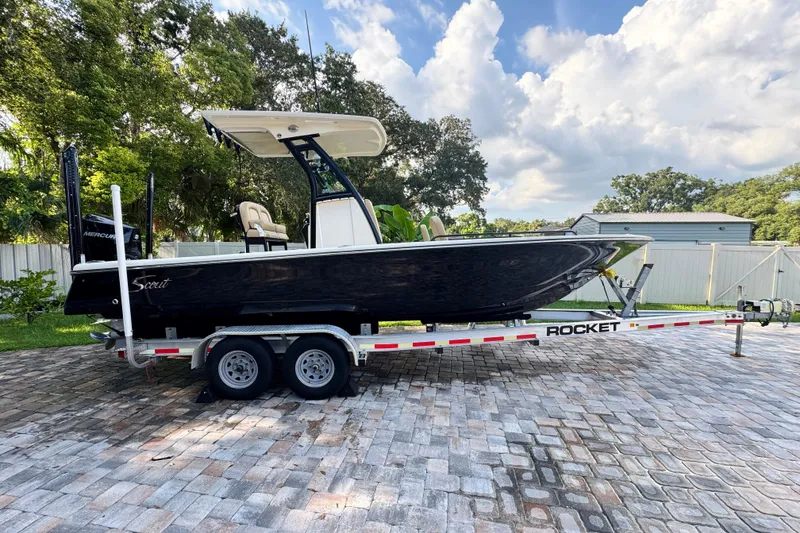 Slide: The Image of 2020 Scout 251 XSS boat on water near modern waterfront buildings. - 0