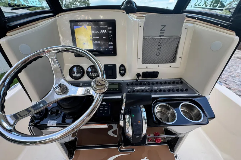 Slide: The Image of 2020 Scout 251 XSS boat interior with Mercury engine, featuring seating and control panel. - 16