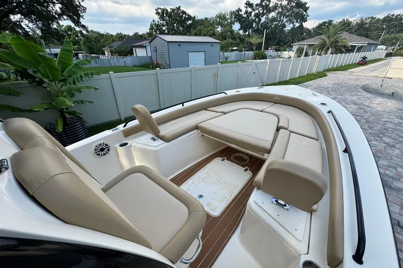 Slide: The Image of 2020 Scout 251 XSS boat with beige seating and Mercury engine in a backyard setting. - 20