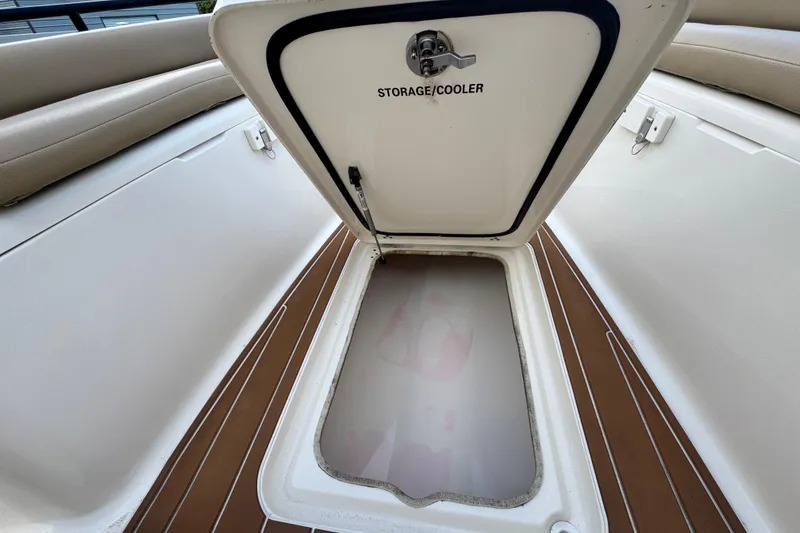 Slide: The Image of 2020 Scout 251 XSS boat with T-top, parked in a residential driveway. - 23