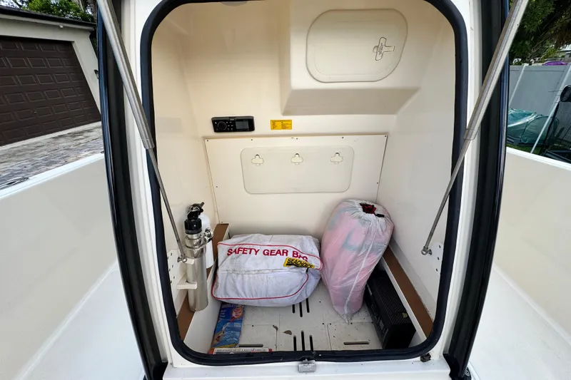 Slide: The Image of 2020 Scout 251 XSS boat with beige seating, parked in a residential driveway. - 28