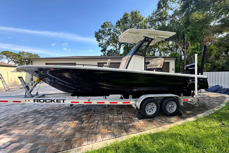 Slide: The Image of 2020 Scout 251 XSS boat on water near modern buildings and palm trees. - 3