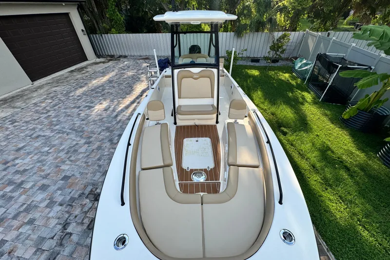 Slide: The Image of 2020 Scout 251 XSS boat with beige seating, parked on a paved driveway. - 34