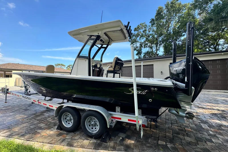 Slide: The Image of 2020 Scout 251 XSS boat docked near waterfront buildings under clear blue sky. - 5