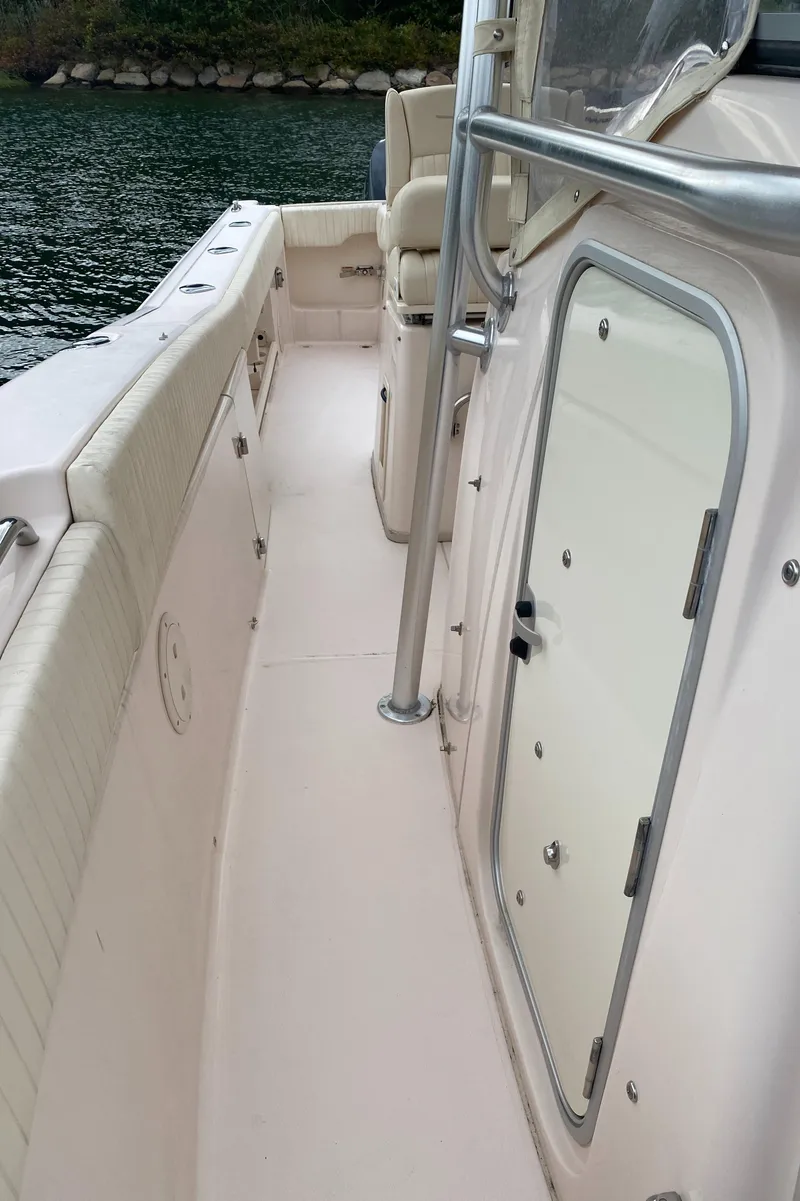 Slide: The Image of 2014 Grady-White Canyon 306 boat interior, featuring side walkway and storage compartment. - 22