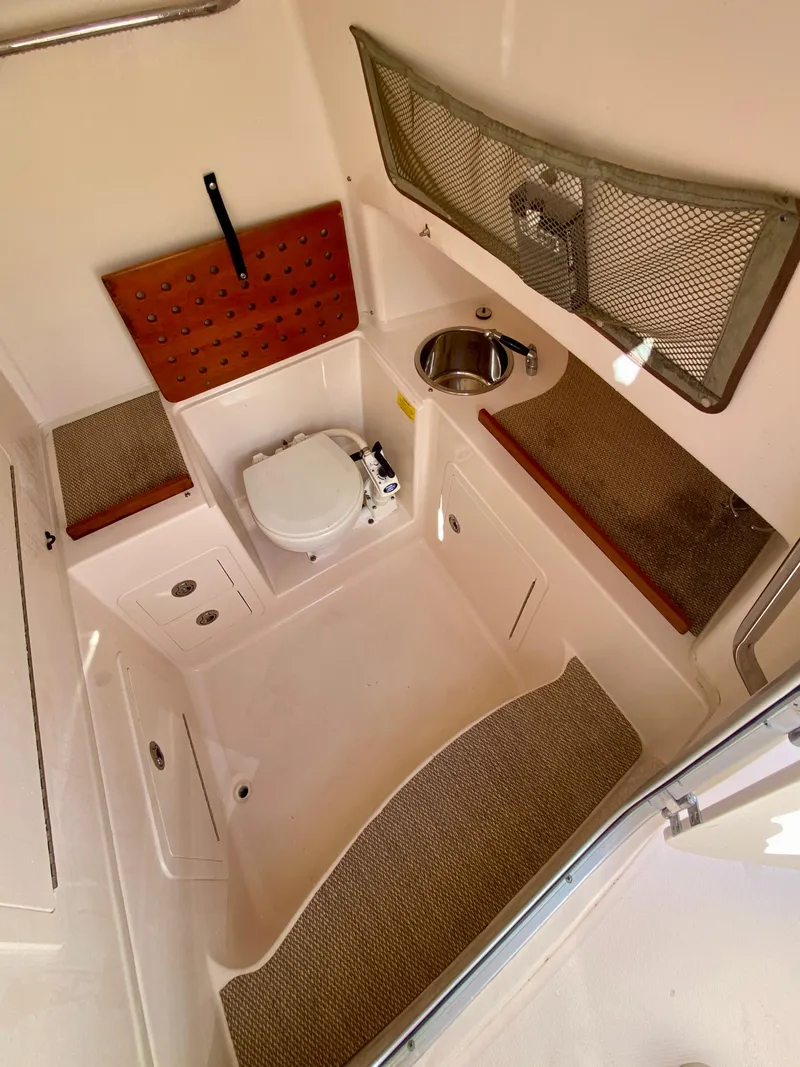 Slide: The Image of 2014 Grady-White Canyon 306 boat interior with toilet, sink, and storage. - 23