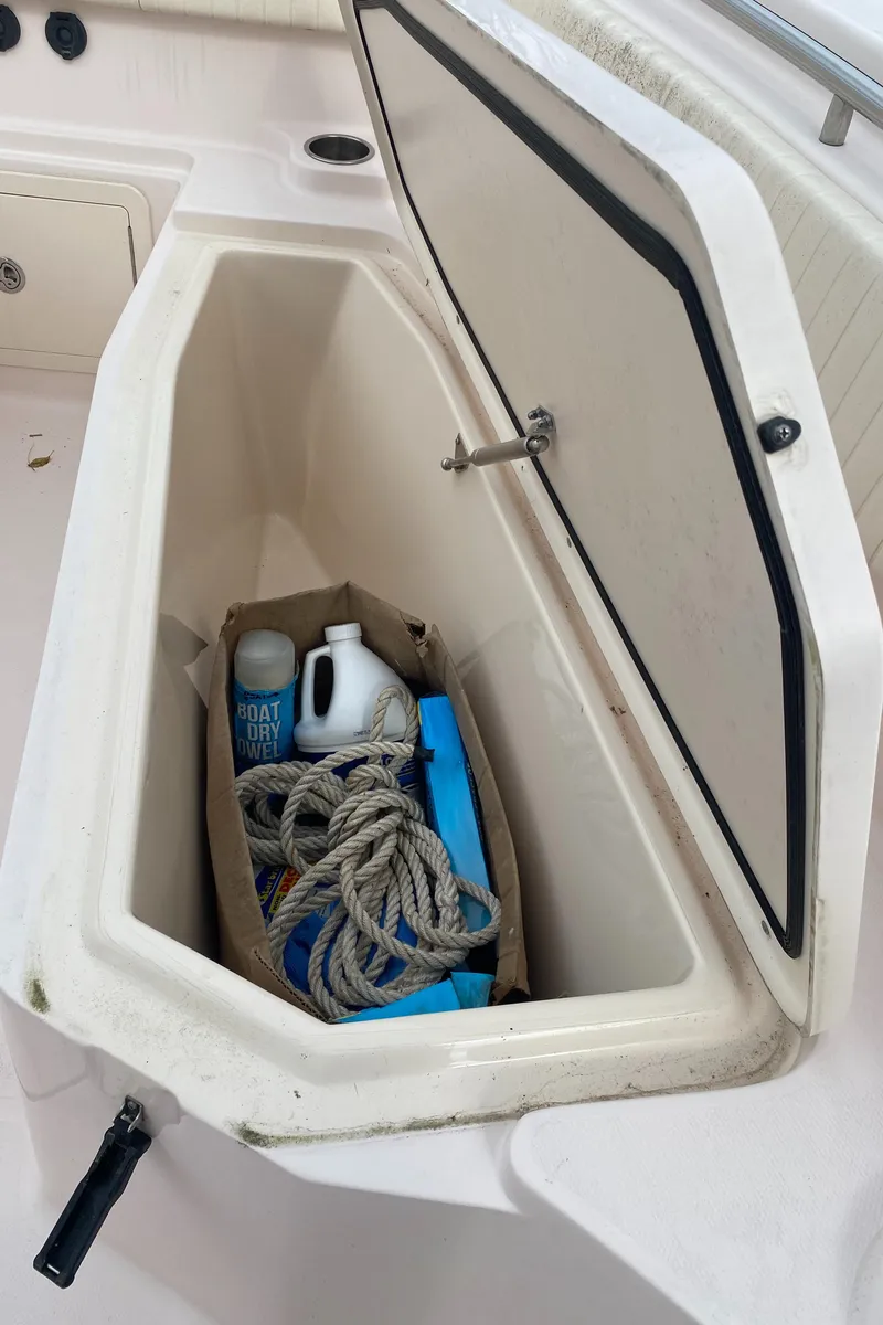 Slide: The Image of Storage compartment on a 2014 Grady-White Canyon 306 boat with rope and supplies. - 27