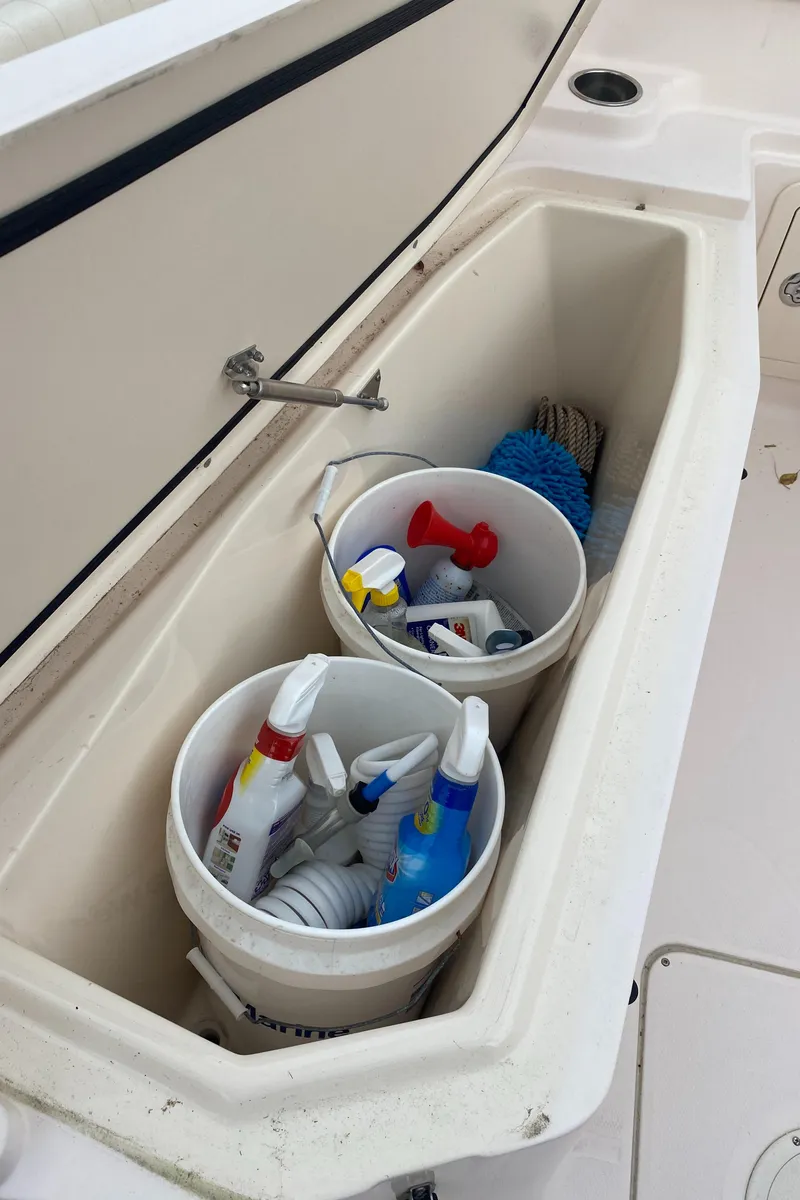 Slide: The Image of Storage compartment on 2014 Grady-White Canyon 306 with cleaning supplies and buckets. - 28