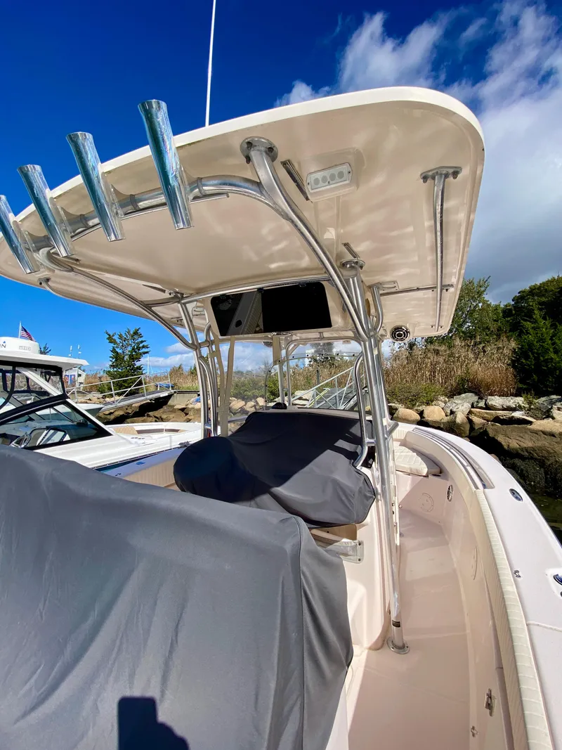 Slide: The Image of 2014 Grady-White Canyon 306 boat with T-top, docked under a clear blue sky. - 6