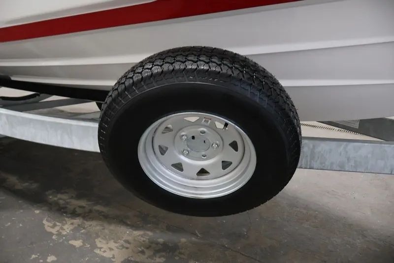 Slide: The Image of Trailer wheel of 2026 Yamaha Boats 222XE, featuring sturdy tire and metal rim. - 44