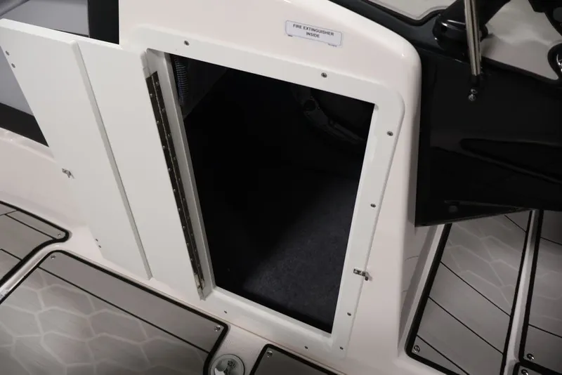 Slide: The Image of Open storage compartment on 2026 Yamaha Boats 222XE with fire extinguisher label. - 31