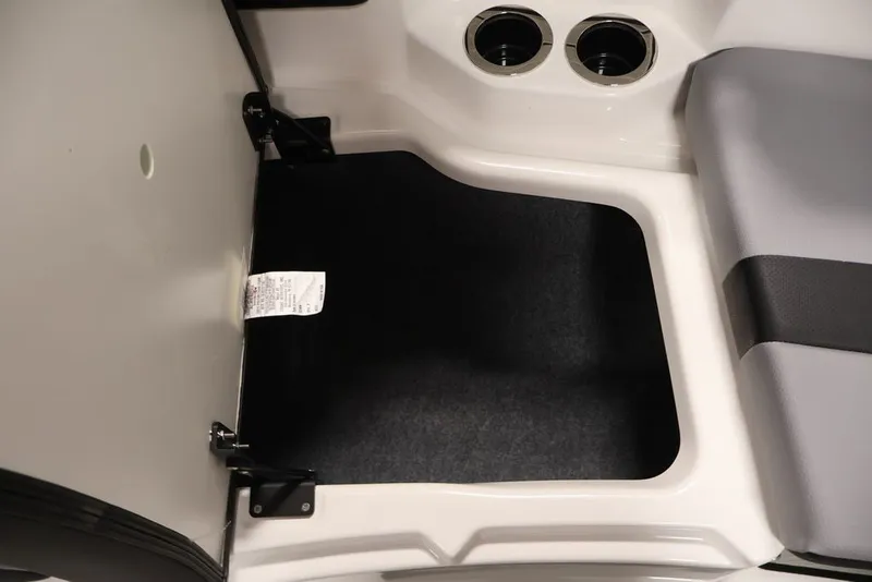 Slide: The Image of 2026 Yamaha Boats 222XE interior storage compartment with cup holders and cushioned seating. - 11