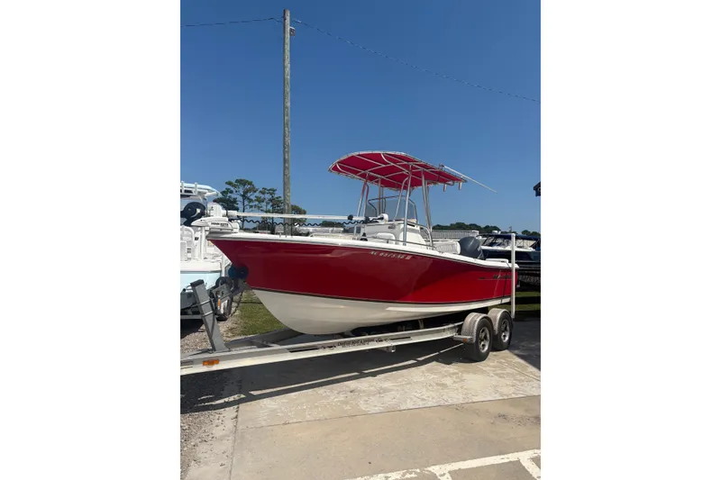 Slide: The Image of Red 2010 Sea Hunt Triton 202 boat on trailer under clear blue sky. - 0