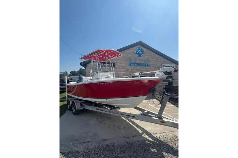 Slide: The Image of 2010 Sea Hunt Triton 202 boat with red hull on trailer at yacht sales. - 1