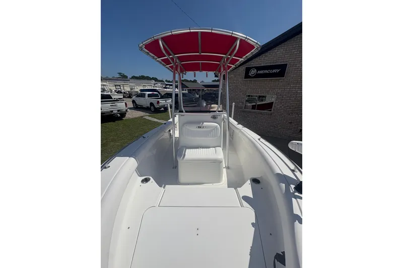 Slide: The Image of 2010 Sea Hunt Triton 202 boat with red canopy, parked near Mercury dealership. - 11